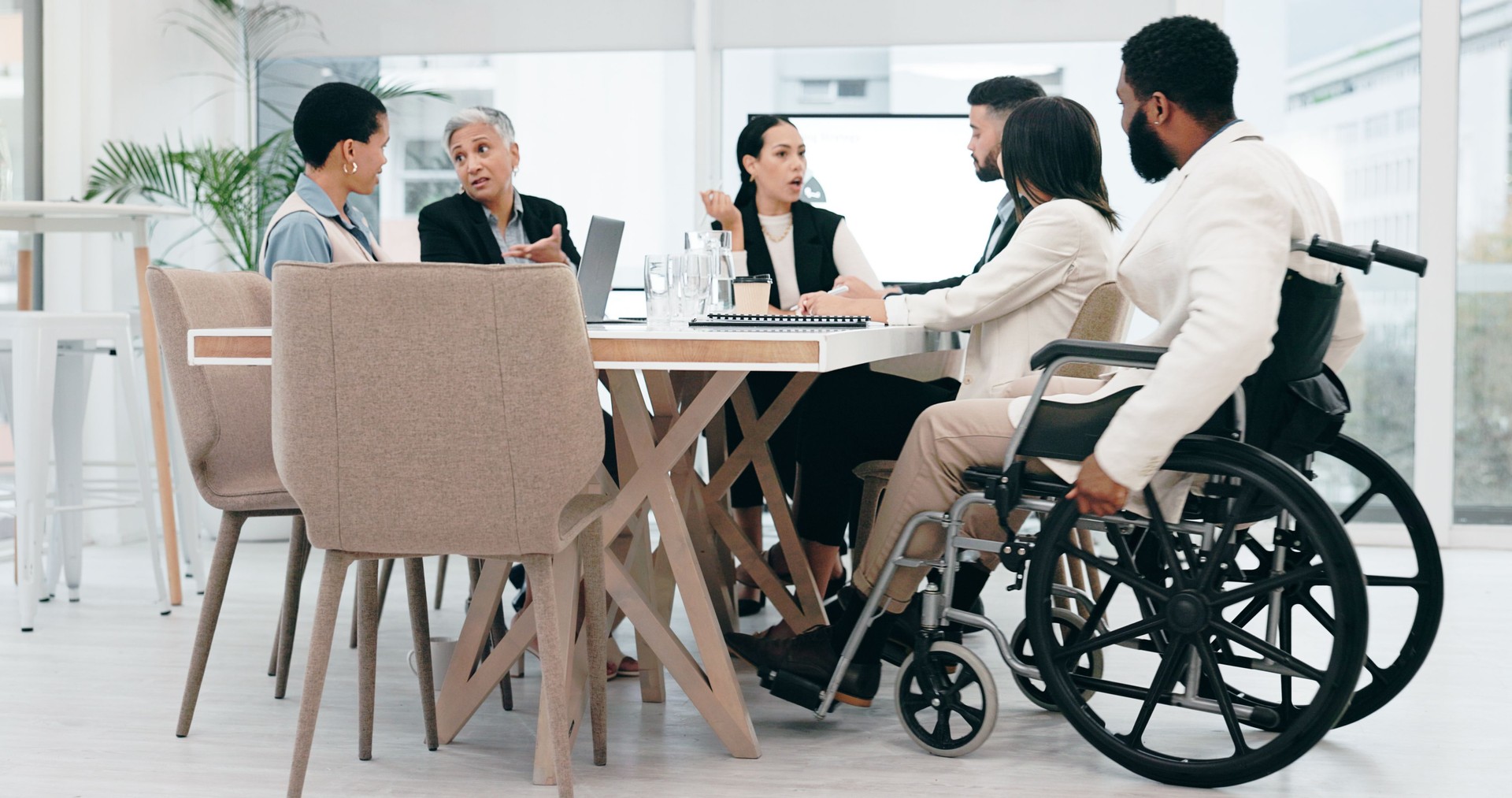 Inclusive, talking and business people in a morning meeting for collaboration, planning or discussion. Happy, diversity and a black man with a disability working at a company with emplyees speaking